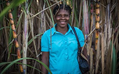 Saincia, woman in Haiti, standing outside, smiling.